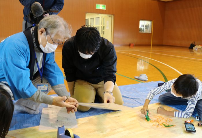 まちのわだい3　竹ひごの骨付けを真剣に教わるお父さん.jpg