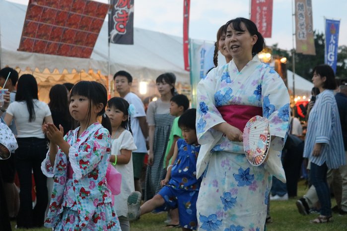 浴衣姿で溝口盆踊りを踊る親子